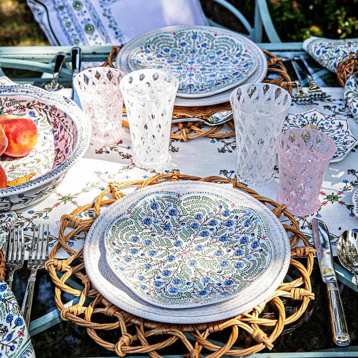 Villa Seville ceramics and linens displayed within a tablescape in an outdoor garden.