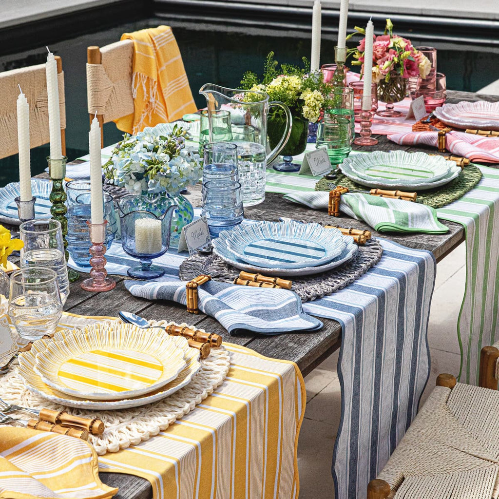 Cabana collection featuring yellow, blue, green and pinks linens and melamine plates within a tablescape.