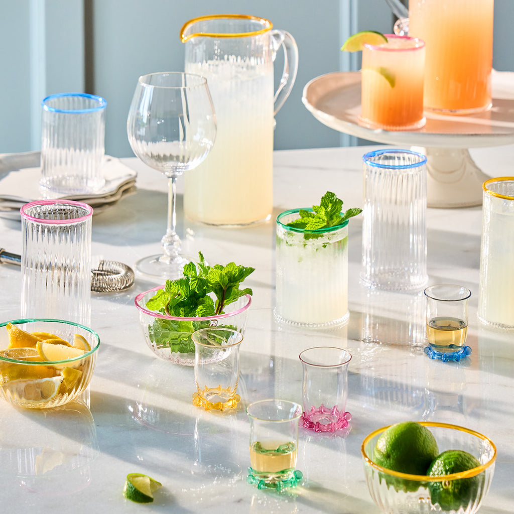 Juliska Nell drinkware in blush, daffodil, chambray and watercress displayed on a table. 